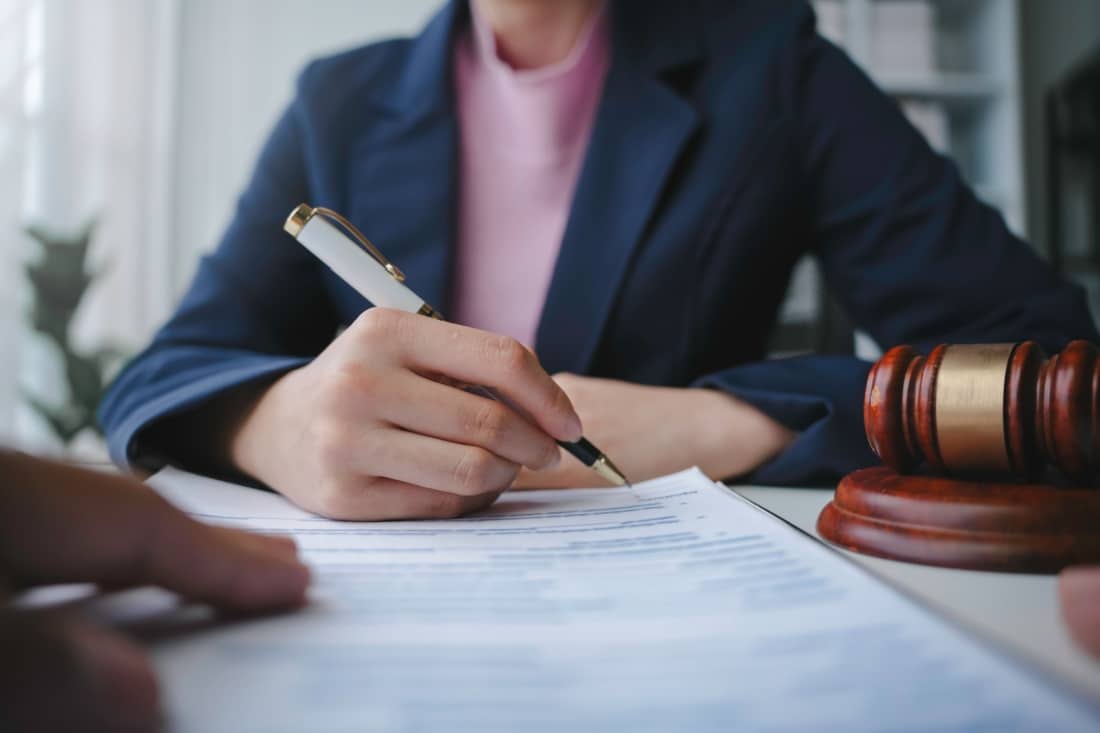 Close up on the hand of a lawyer signing a document.